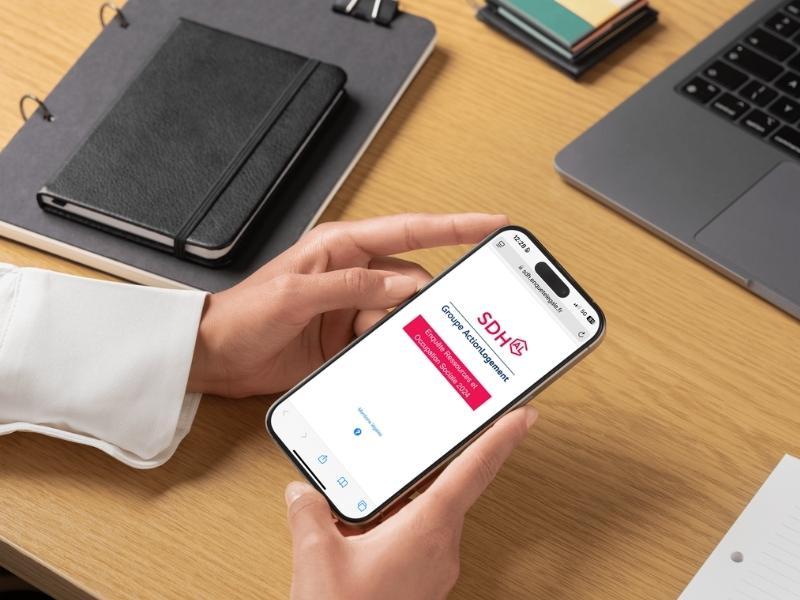 Une personne tient un smartphone, elle consulte une page web.