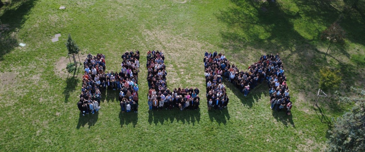 Regroupement de salariés des bailleurs sociaux formant les lettre H, L et M dans un parc.