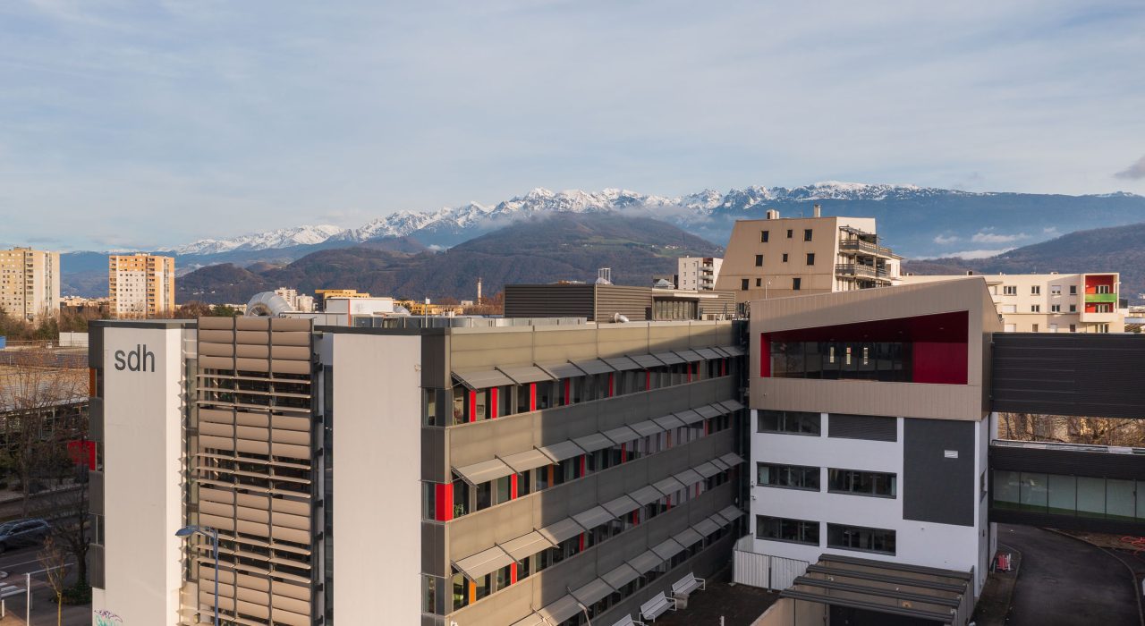 Vue aérienne du siège de la SDH avec la chaîne de Belledonne en arrière plan