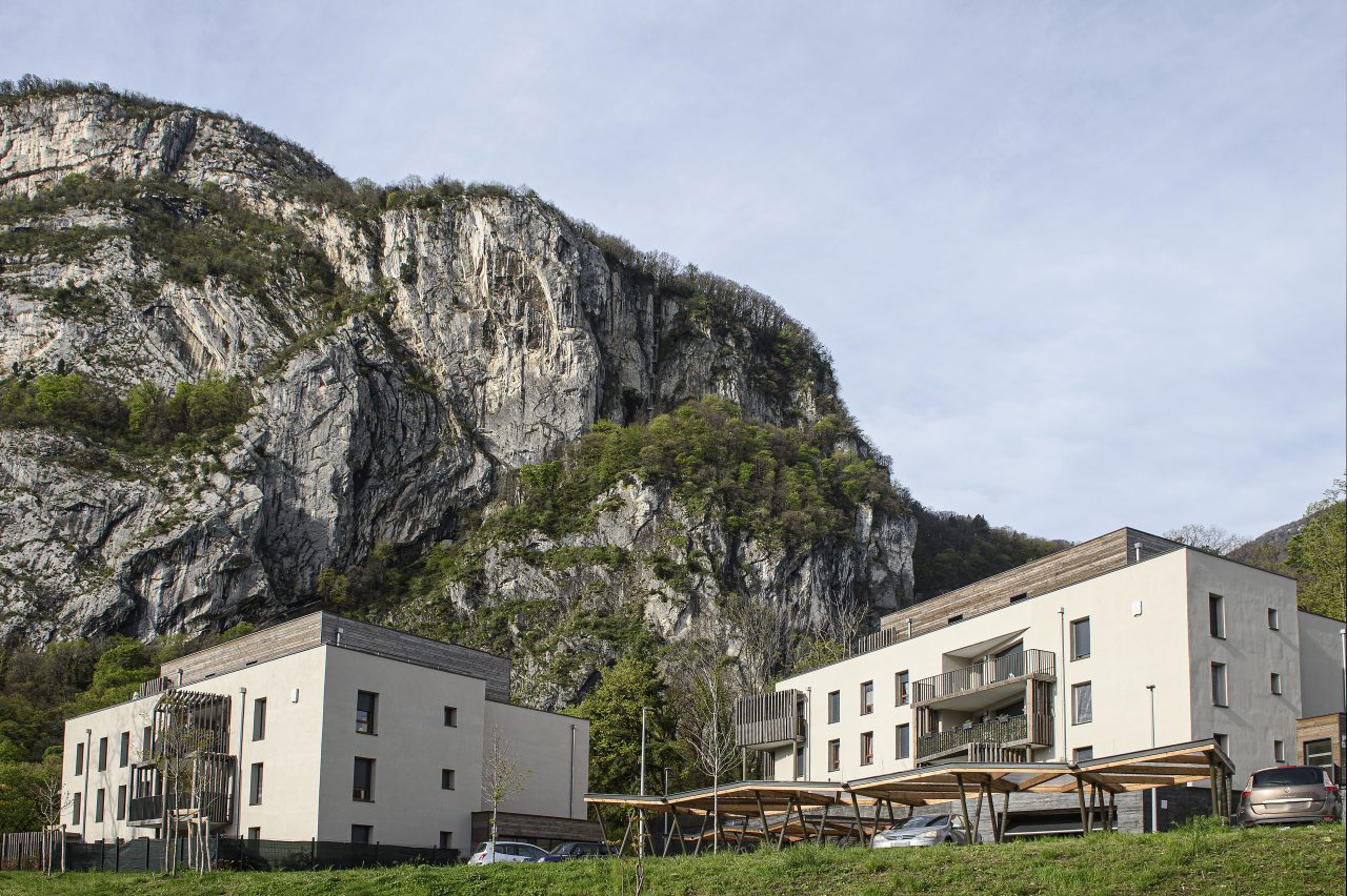 Deux bâtiments d'habitation au pied d'une falaise
